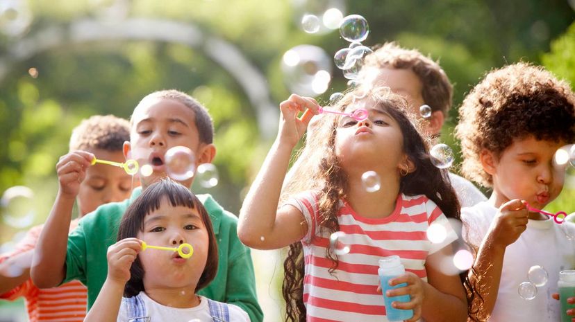 Children outdoors blowing bubbles