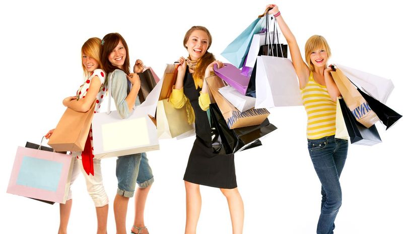 Four young women carrying shopping bags