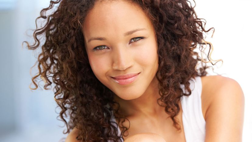 pretty woman curly brown hair tan skin white tank top