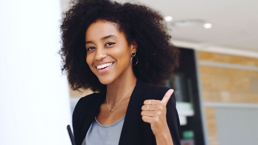 Confident young businesswoman showing a thumbs up gesture