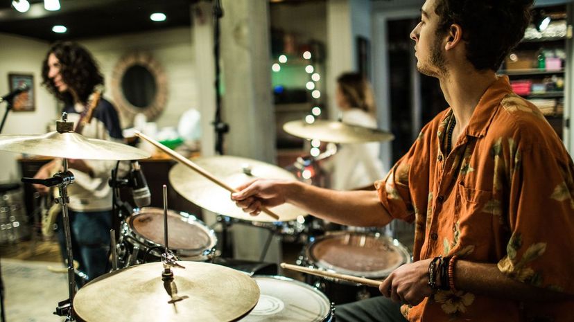 Young man playing drums in rock band