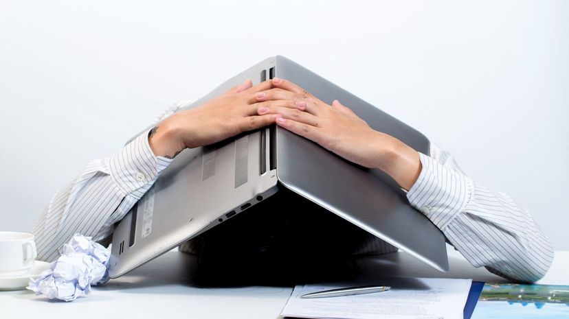 Stress man hiding under laptop