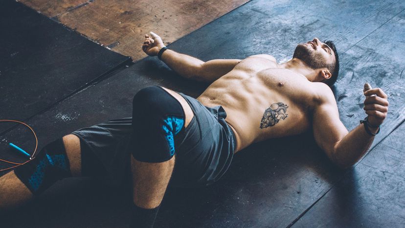 handsome shirtless man on floor of gym workout