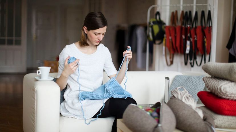 Fashion designer is knitting in her showroom