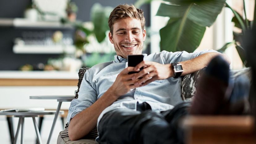 Man using cellphone relaxing on couch