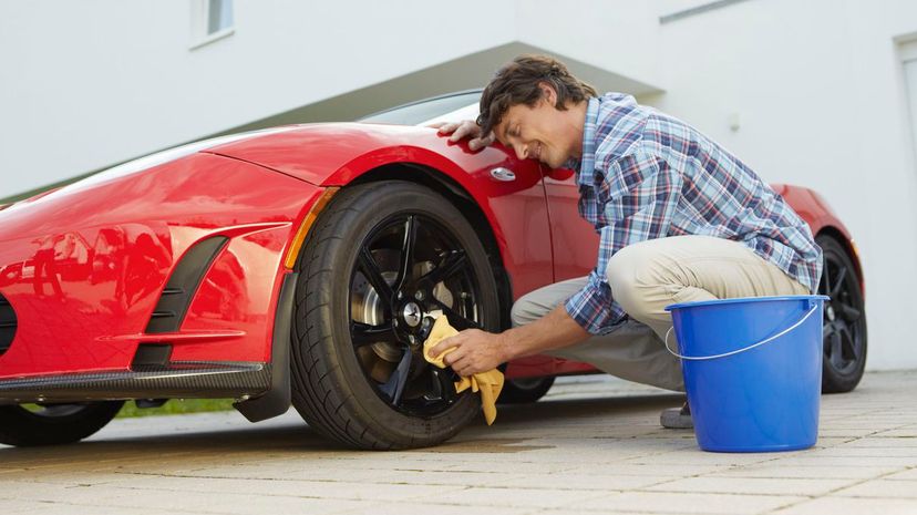 Man proudly cleaning his electric car