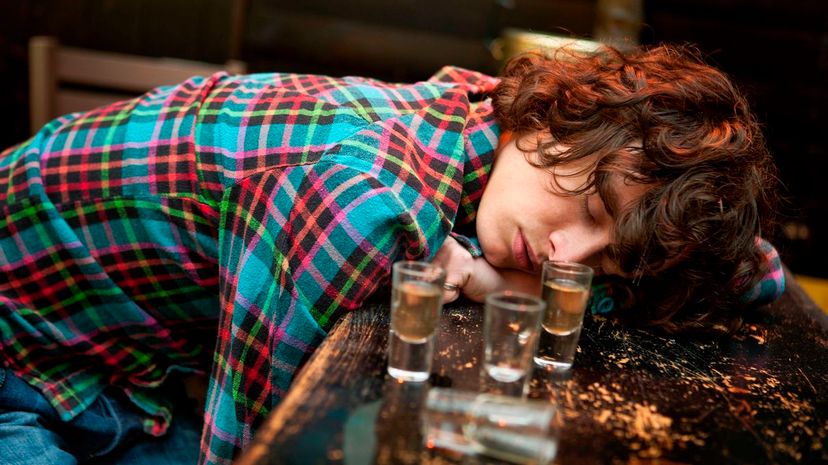 Drunk man slumped on bar asleep