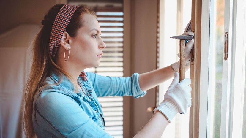 Woman repairing window at home