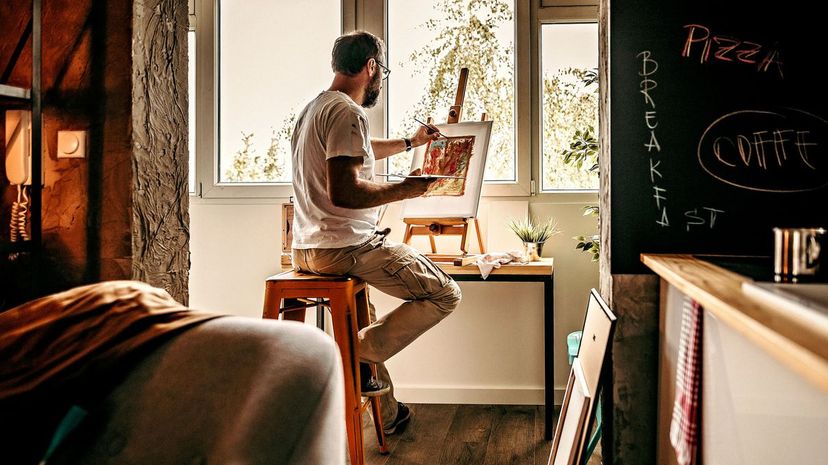 Man in his art studio working on canvas painting