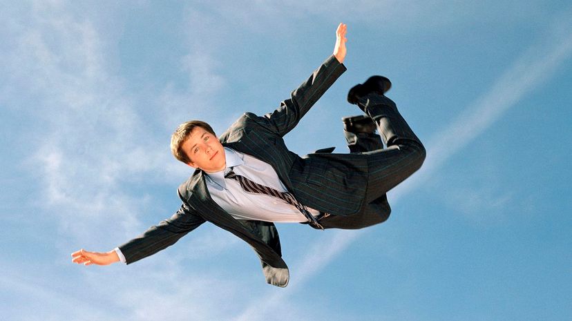 Young businessman soaring through sky