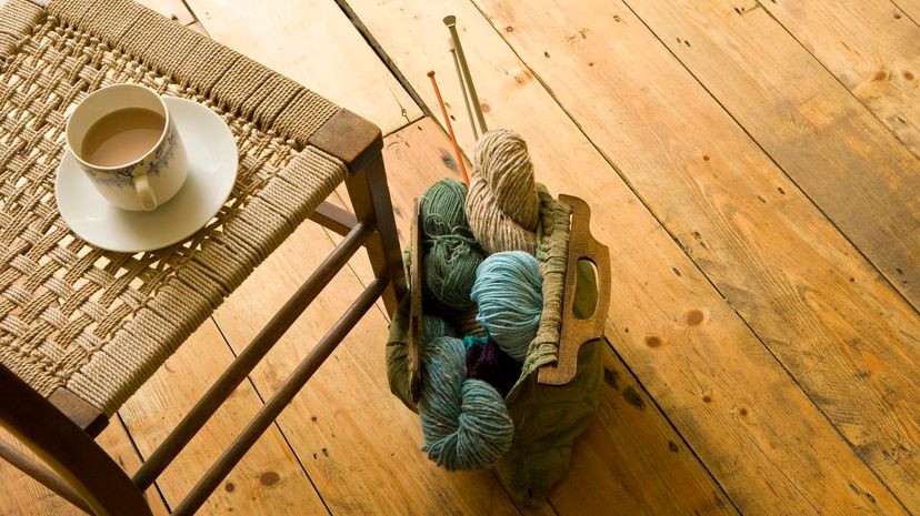 view of knitting supplies and cup on chair