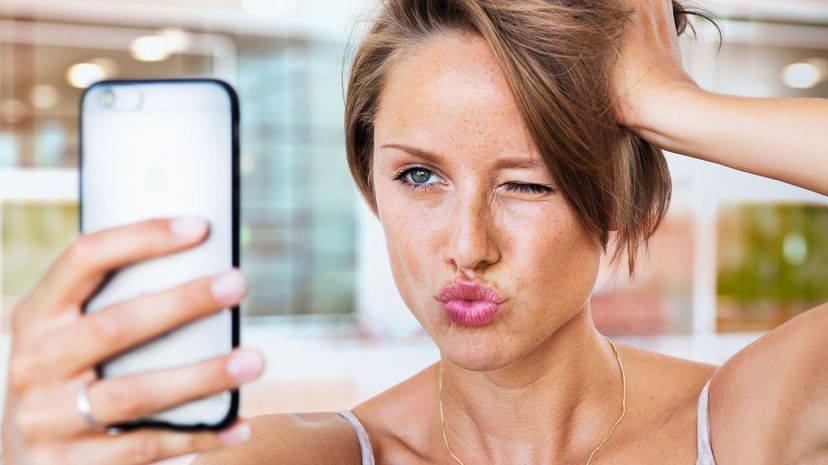 Woman taking selfie, kissing pose