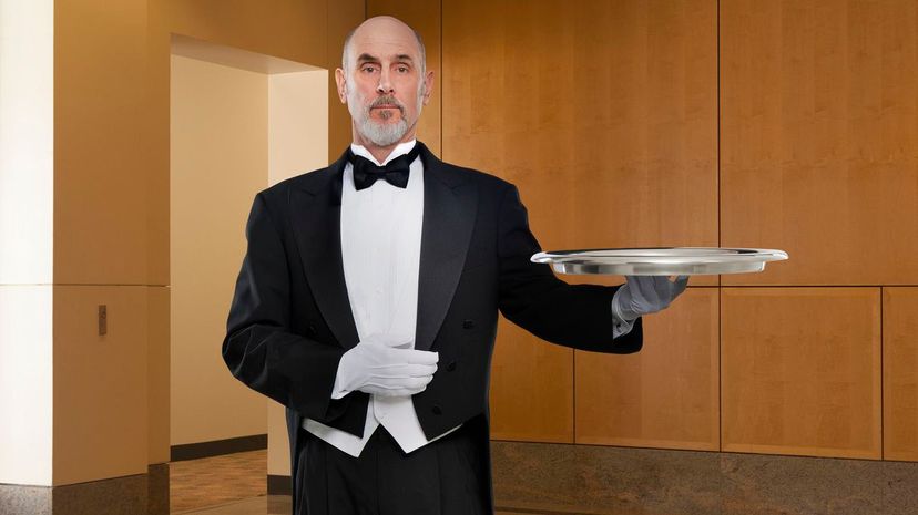 Serious butler holding tray