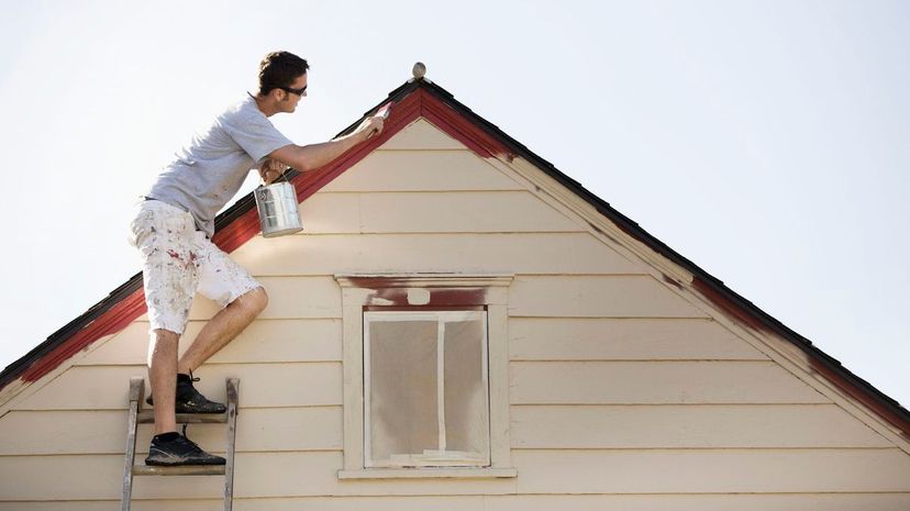 Man painting edge of roof