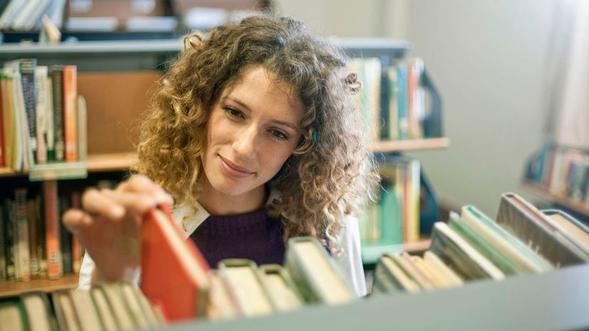 Student searching for book in library