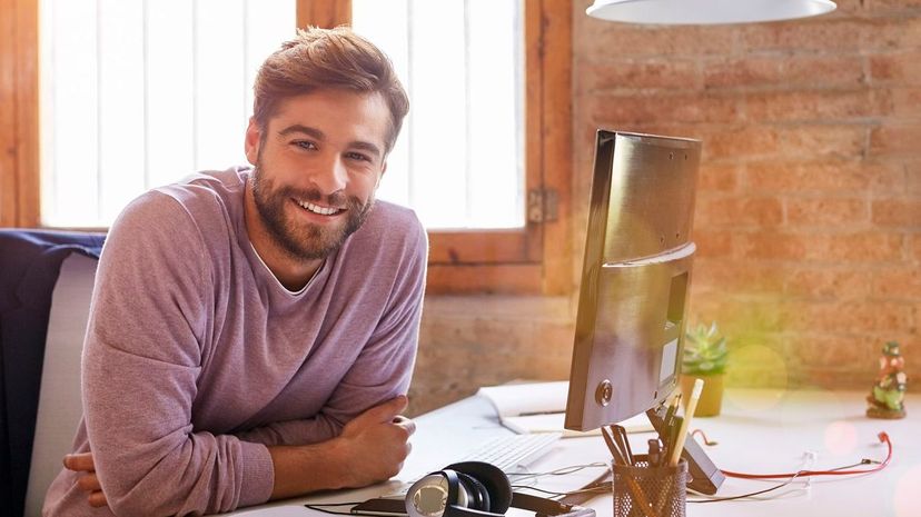 Confident businessman leaning on desk