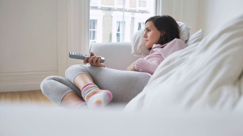 Young woman relaxing at sofa using remote control
