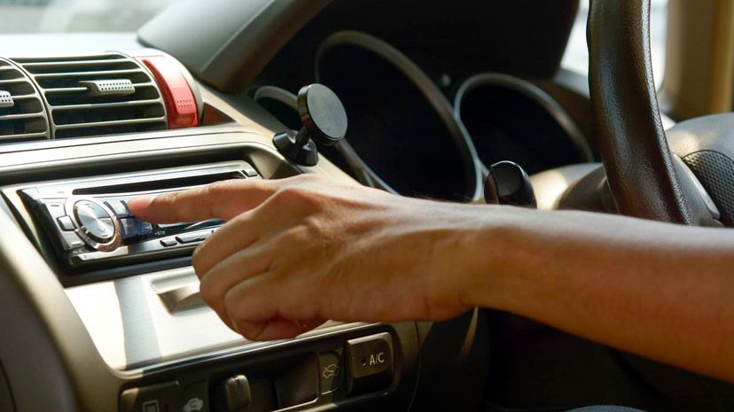 Man hand on turn on radio in the car