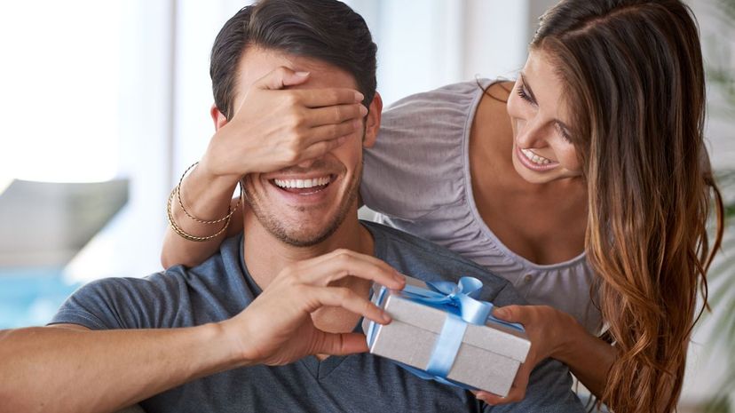 Young woman surprising her partner with a gift