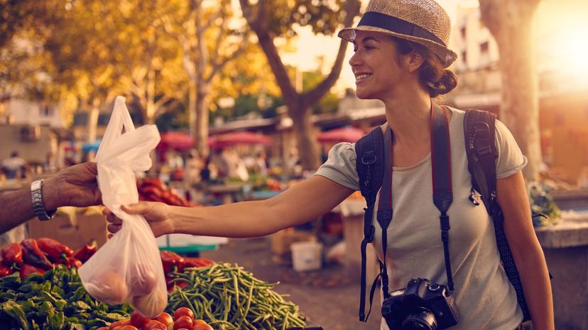 Woman buying fruit and vegetables at a market in a foreign city