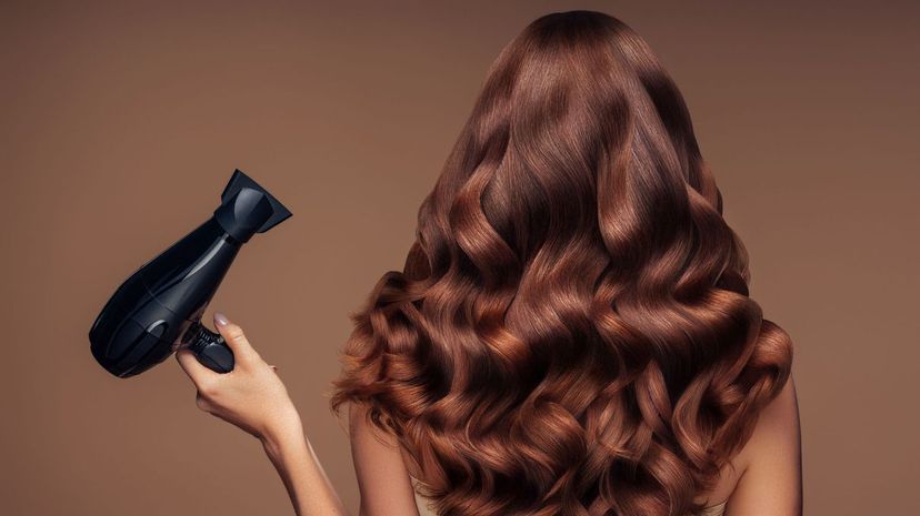 Girl with a beautiful hairstyle holding a hairdryer