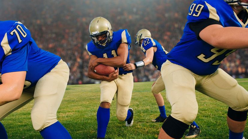 American football players running with ball