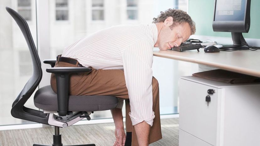 Exhausted man sleeping on computer keyboard