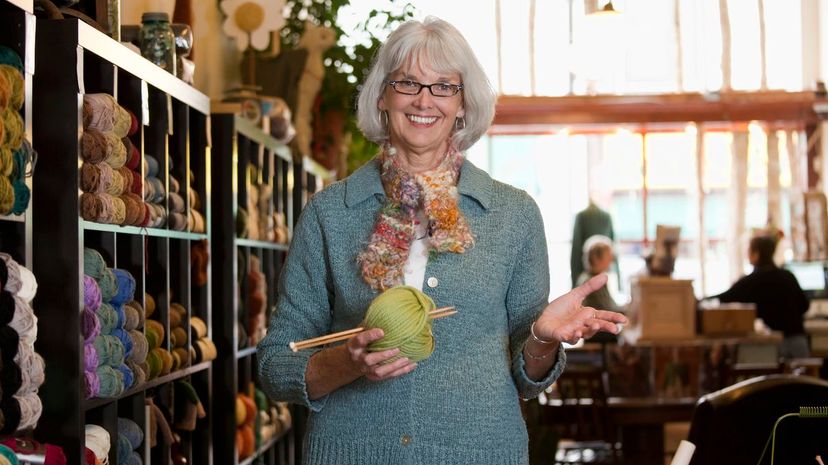 woman holding ball of yarn in shop