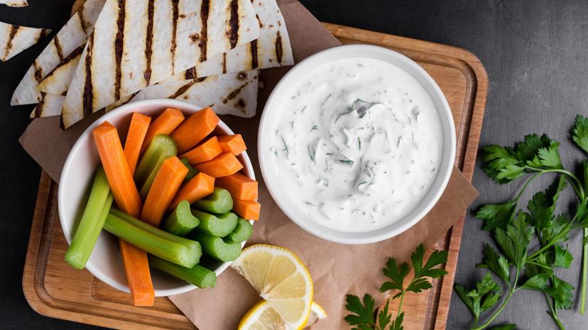 Yogurt sauce with parsley served with fresh carrot and celery sticks
