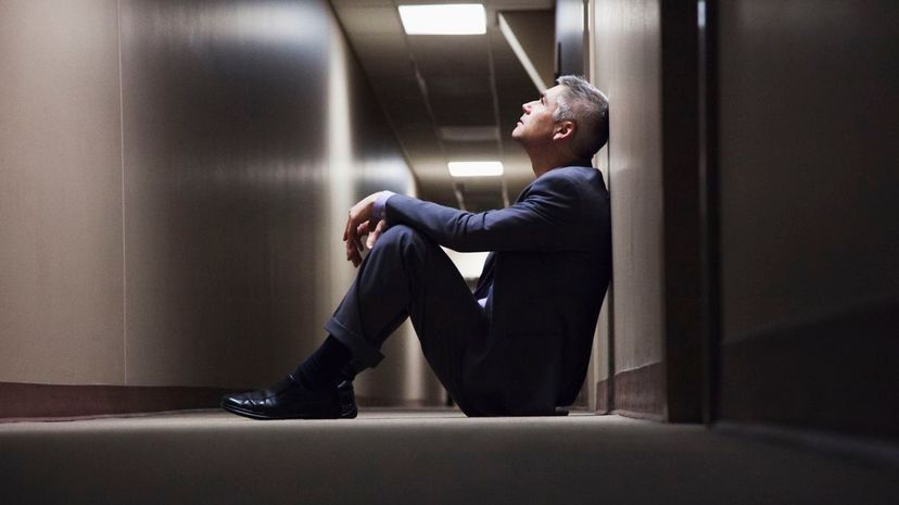 Businessman sitting on floor in corridor