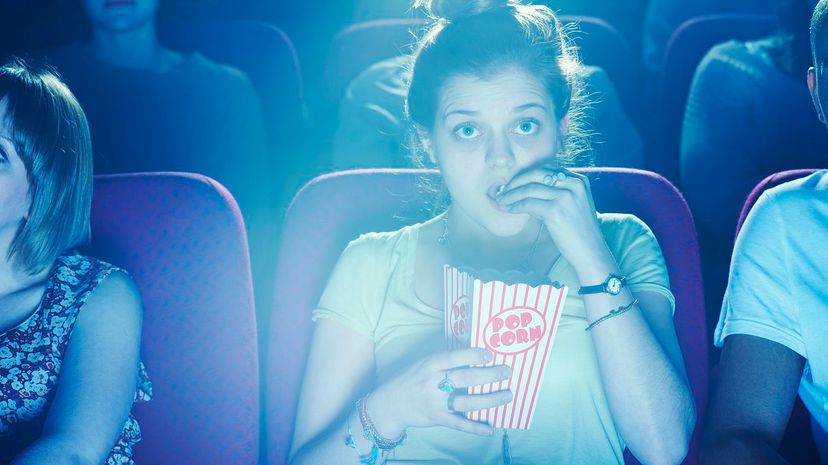 Woman watching movie and eating popcorn