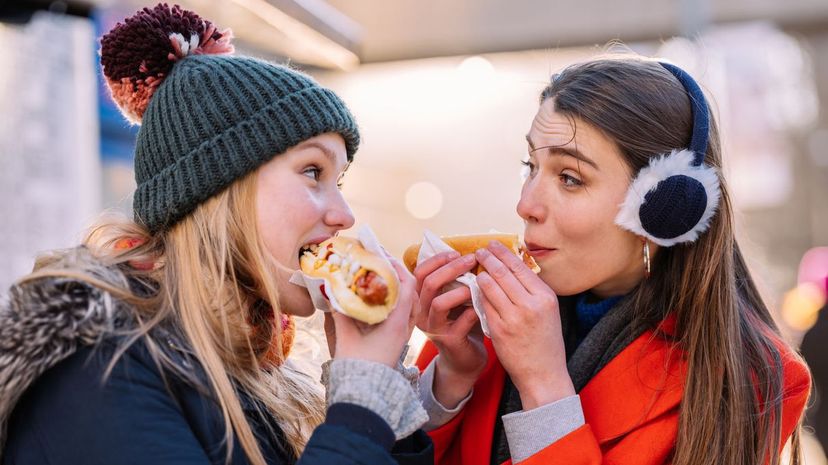 Two teenage women eating hot dog