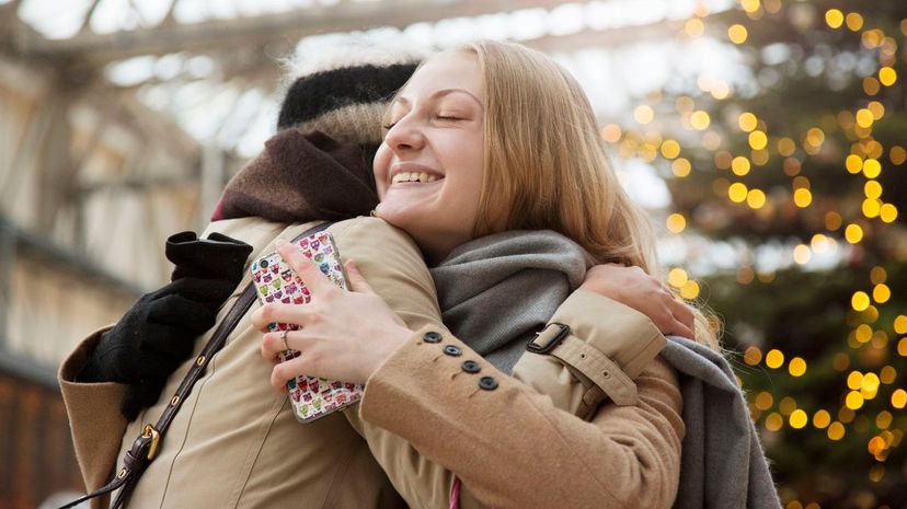 Woman embraces her friend at railroad station