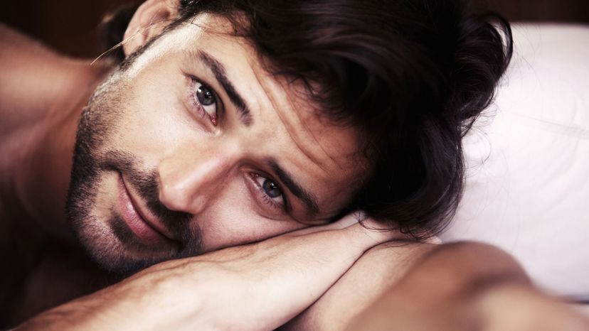 cute guy wistful look scruffy beard laying down