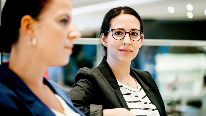 Young Woman Listening To Her Colleague During Meeting