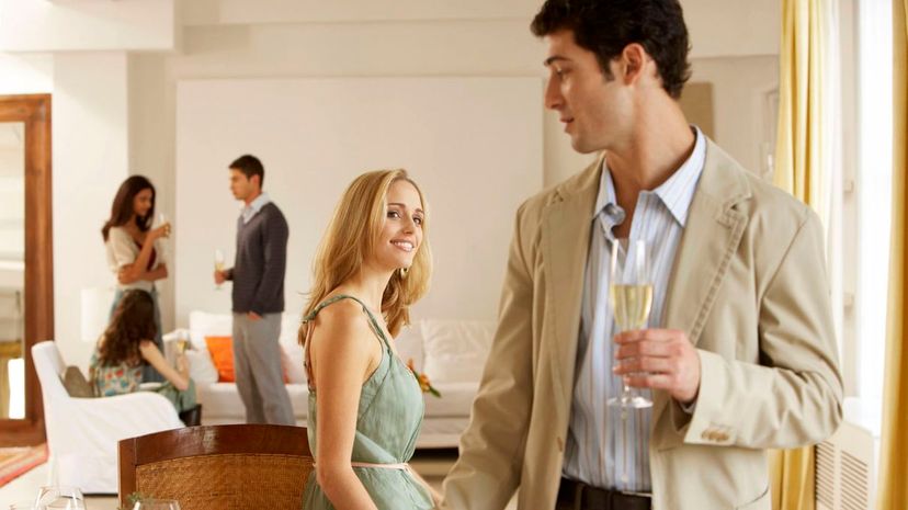 Woman smiling at man standing by dining table