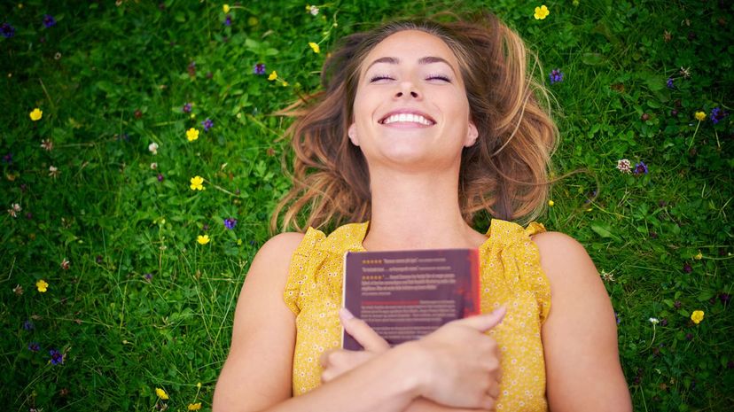 Woman relaxing on grass with a book