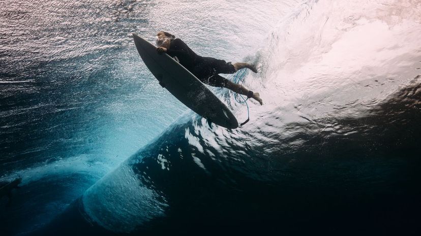 Surfer dives beneath a wave