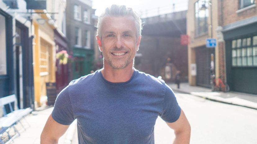 handsome silver hair blue t-shirt city smiling at camera