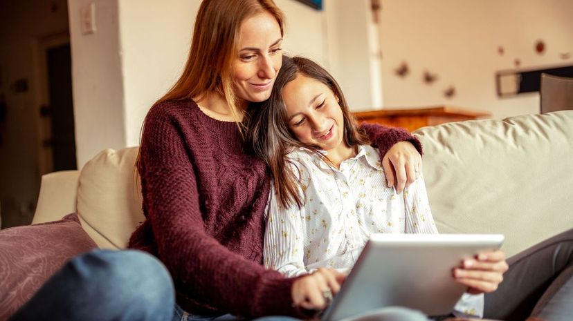Mother and daughter spending time together using digital tablet