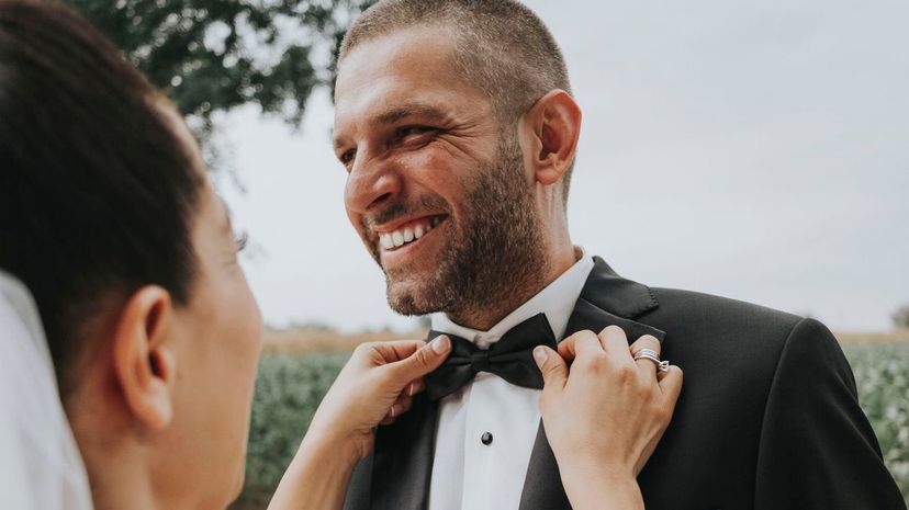 Fixing groom's bowtie at a wedding