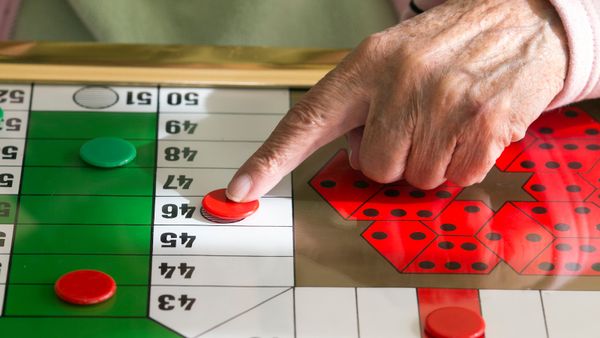 Woman playing a game of table Parcheesi