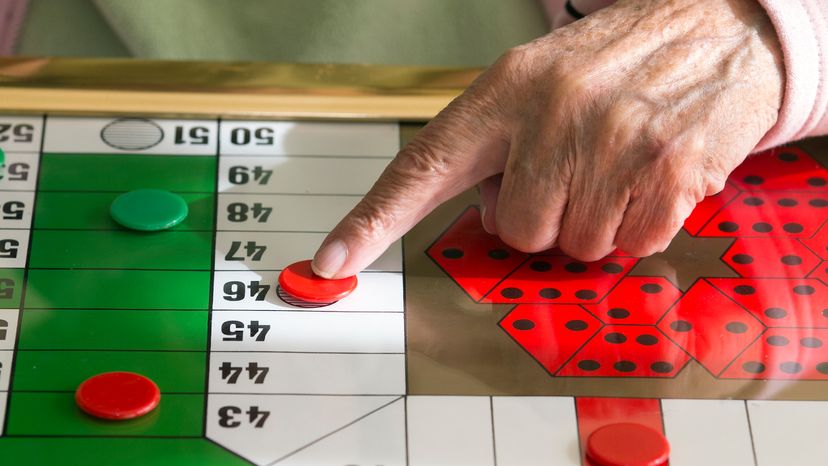 Woman playing a game of table Parcheesi