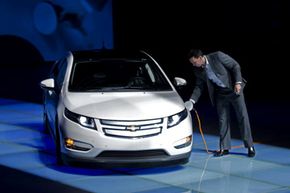 A staff member of GM China charges up a Chevrolet Volt during a ceremony to send a pair of Volts to Shanghai Expo Bureau in Shanghai, China. See more [url='531767']pictures of plug-in hybrid cars[/url].