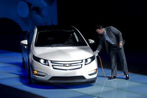 通用汽车中国的一名工作人员在仪式上向雪佛兰伏特（Chevrolet Volt）指控，将一对伏特送到上海上海的上海博览局。查看更多插电式混合动力汽车的图片。“width=