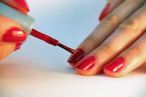 Iron oxides and other pigments in red nail polish can potentially stain the nails underneath.