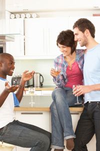 three people talking in a kitchen