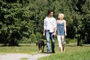 couple walking dog in park