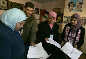 Employees from the Palestinian statistics department check forms to be used for the Palestinian population census during house-to-house visits in the West Bank city of Ramallah, December 2007.
