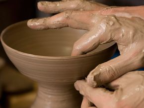 Potter moulding clay on pottery wheel